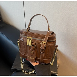 Detail der vintage braunen Eimertasche mit Steppmuster und goldenem Ketten-Schultergurt