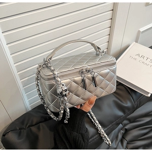 Detail of silver quilted handbag with metal chain strap and dual zipper closure
