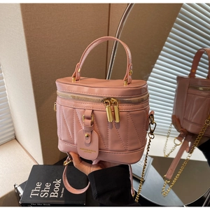Detail der rosa Beuteltasche mit V-Steppung, goldener Hardware und Metallkettenriemen