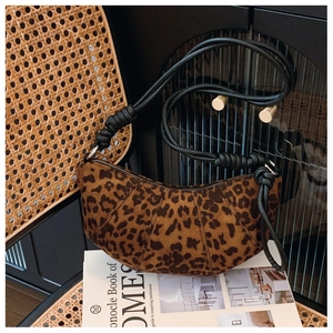 Detail of leopard print crescent bag with black knotted strap and pleated suede texture