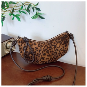 Detailed view of leopard print suede crescent bag with knotted rope strap and metal zipper