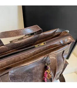 Close-up of vintage dark brown faux leather backpack with metallic zipper and charm