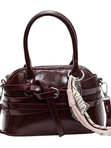 Deep burgundy glossy leather shell bag with top handles and woven cord charm