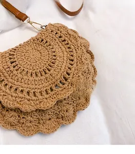Detail of woven beach bag showing shell-shaped edge and premium faux leather strap