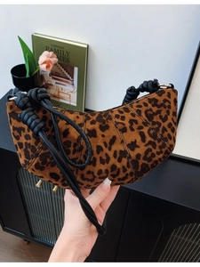 Stylish leopard print hobo bag with a unique twisted black handle and crescent shape
