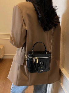 Schicke Beuteltasche aus schwarzem Lackleder mit Steppmuster und Goldkette