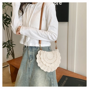 Detail of bohemian hand-woven cotton shoulder bag with elegant scalloped edges and leather strap
