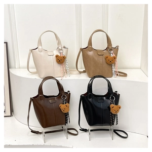 Set de cuatro bolsos bucket de cuero sintético en varios colores con dijes de oso