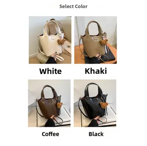 Detalle de cuatro bolsos de hombro tipo cubo con colgantes de oso en blanco caqui y café