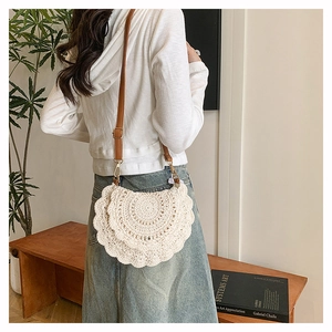 Detail of bohemian hand-woven crochet bag featuring mandala patterns and leather strap