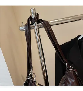Detail of reinforced handle with silver metal rings on dark brown oil wax leather tote