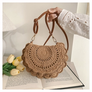 Detail of bohemian woven brown crossbody bag with scalloped texture and leather strap