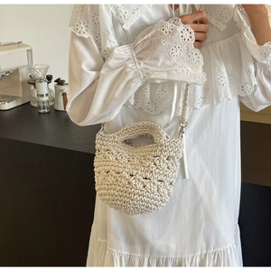 Detail einer cremeweißen handgewebten Beuteltasche mit Texturen und silbernen Haken