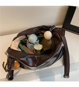 Top-down view of spacious interior of dark brown patent leather tote bag showing high capacity