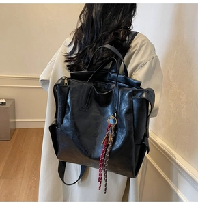 Close-up of black PU leather backpack with a decorative knotted rope tassel detail