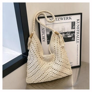 Close-up of beige crochet woven pattern and tassel detail on summer beach tote bag