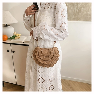 Bohemian woven bag styled with white embroidery dress in a cozy Nordic home interior