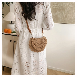 Detail of bohemian woven bag with scalloped edges and adjustable brown leather strap