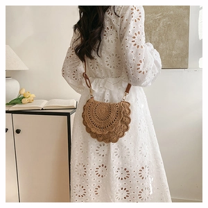 Detail of woven straw crossbody bag styled with a white dress for a bohemian look