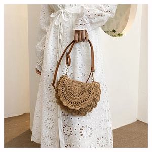 Detail of bohemian hand-woven half-moon bag with leather strap and golden buckle