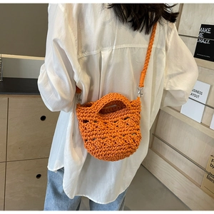 Detailansicht der orangefarbenen Häkeltasche mit gewebter Textur und geflochtenem Gurt