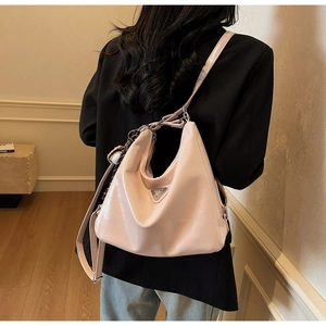 Detail of pink patent leather hobo bag featuring metallic chain and sphere charm