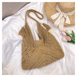 Detail of bohemian woven tote bag with fringe accents and textured diamond pattern