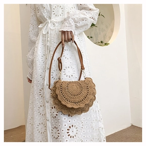 Detail of bohemian woven handbag showing hollow crochet patterns and adjustable leather strap