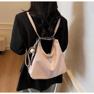 Pink glossy hobo bag detail with metal triangle plate and baseball keychain pendant