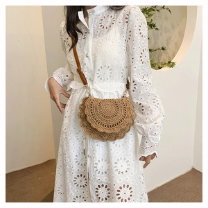 Detail of bohemian hand-woven hollow round crossbody bag with adjustable leather strap
