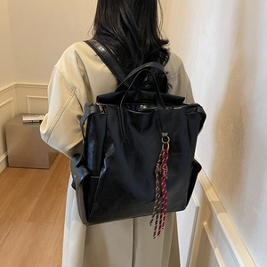 Retro black leather backpack for women with large capacity and woven charm detail