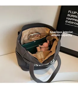 Dettaglio interno di una grande borsa tote in tela grigia che mostra lo spazio per oggetti