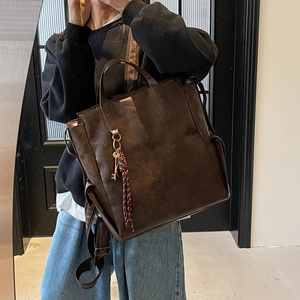 Vintage dark brown large capacity faux leather backpack and handbag for women shown on model