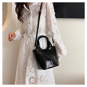 Detalle de la textura de cuero negro brillante y el elegante asa del bolso de mujer