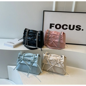 Collection of four pleated crossbody bags with bows in black, pink, blue, and white colors