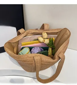 Detailed top view of a large straw tote bag showing spacious storage with personal items