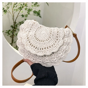 Detailed crochet texture and seashell pattern on a bohemian woven crossbody beach bag