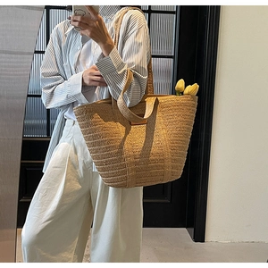 Detail of hand-woven straw tote bag texture with natural beige finish and sturdy handles