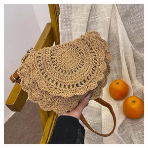 Detailed view of handmade woven straw bag with unique layered circular weaving and leather strap