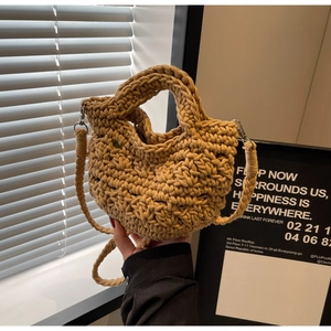Detailansicht der kamelfarbenen geflochtenen Beuteltasche mit Riemen und Metallhaken