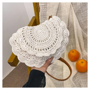 Detail of bohemian cream woven bag featuring layered petal textures and brown leather strap