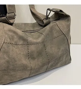 Detail view of large matte shoulder bag with diamond stitching and metal hooks