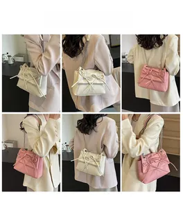 Detail showing cream and pink crossbody bags with bows and silver chain straps