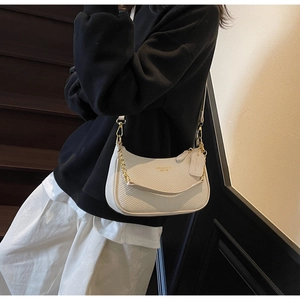 Detail of cream woven crescent bag featuring gold chain and logo for stylish women