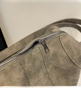 Detail of smooth metal zipper and quilted matte texture on a large capacity shoulder bag