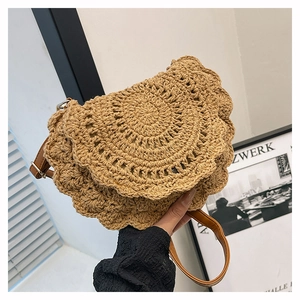 Detail of bohemian hand-woven round bag with scalloped edges and brown leather strap