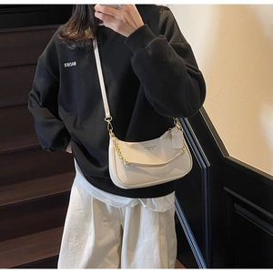 Detail view of the woven texture and golden chain strap on this beige hobo shoulder bag