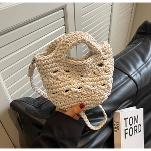 Detail der handgefertigten cremefarbenen Häkeltasche mit Fokus auf Textur und Griffe