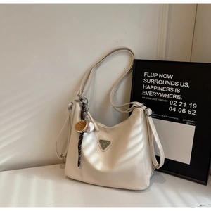 Detail of cream large capacity hobo bag with sporty charms and silver triangle logo