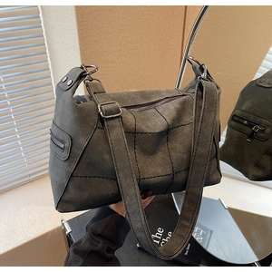 Detailed view of dark grey frosted leather crossbody bag with vintage stitching and side zipper